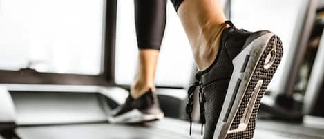 A close-up of a person's foot wearing a running shoe on a treadmill.