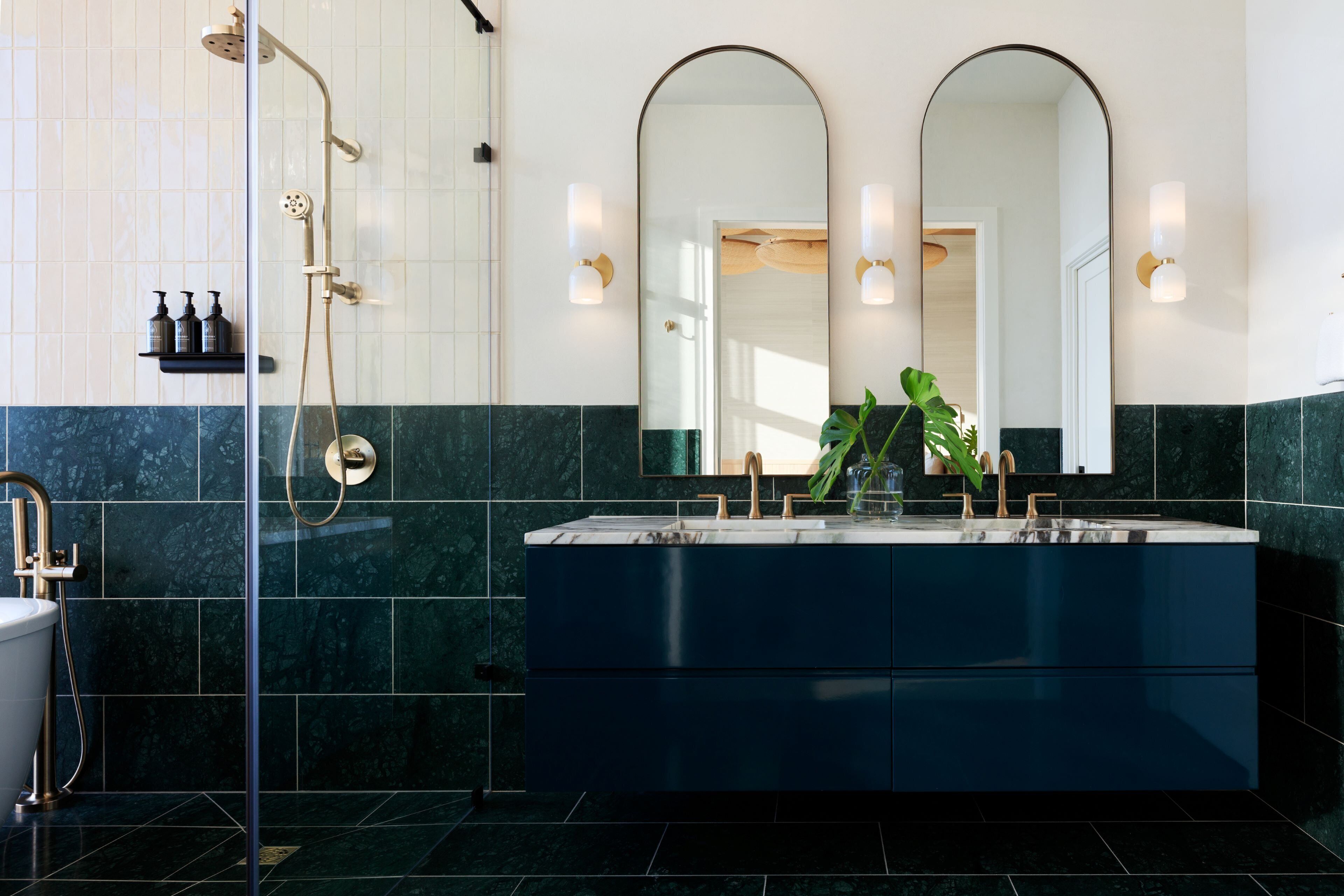 A modern bathroom with a large mirror, a shower, and a vanity with a sink.
