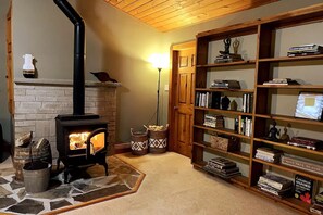 A cozy room with a fireplace, a bookshelf, and a door.