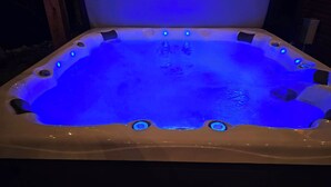 Ein Whirlpool mit weißer Außenhülle und blauer LED-Beleuchtung.