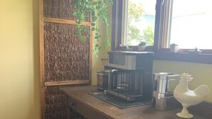 Una cocina con encimera de madera, cafetera y planta colgante.