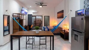 Una sala de estar moderna con un sofá, una mesa de centro, un televisor y un comedor con una mesa y sillas.