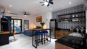 Una cocina moderna con encimera negra, electrodomésticos de acero inoxidable y salpicadero con diseño.