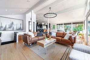 A spacious living room with a large sofa set, a coffee table, and a chandelier.
