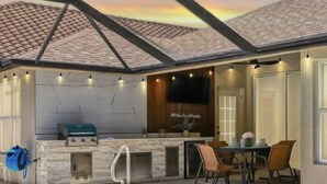 A covered outdoor area with a pool, barbecue grill, and seating area. - LUXURY Villa AZUL Naples with HEATED SALT WATER POOL (Naples)