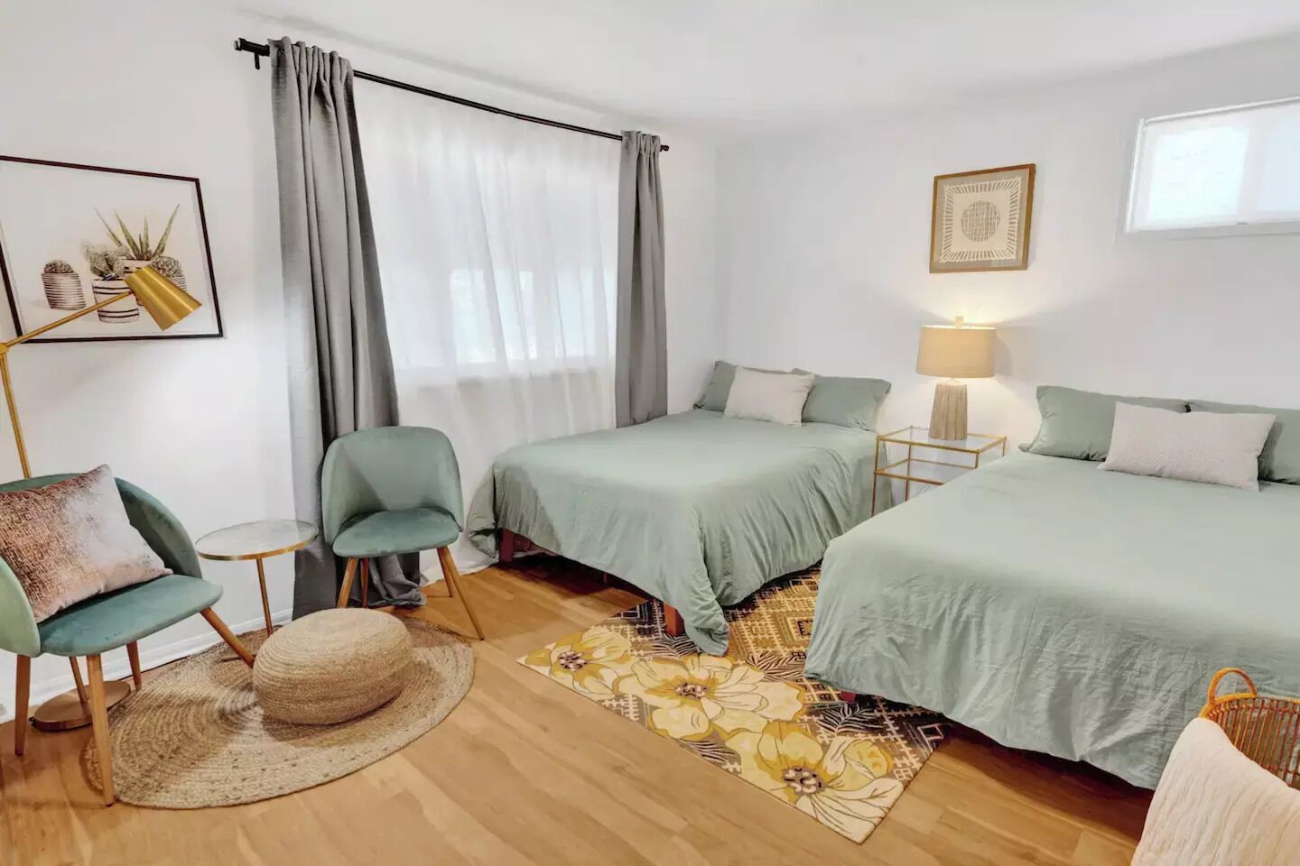 Une chambre d’hôtel avec deux lits, une chaise, une petite table, une lampe et un tapis décoratif.