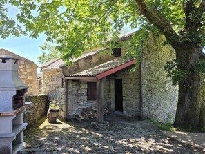Ein Gebäude aus Stein mit einem Ziegeldach und einer Holztür.
