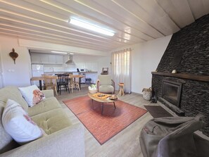 Una sala de estar con sofá, mesa de centro y chimenea.