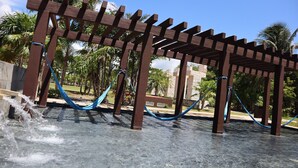 A wooden pergola structure with blue ropes hanging from it, set against a backdrop of palm trees and a clear sky. - Playa del Carmen (Playa del Carmen)