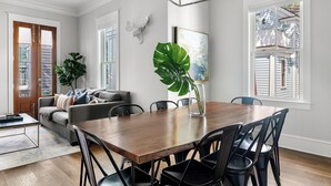A dining area with a wooden table, black chairs, and a large green plant. - Old Village | Amazing Location | The Big Spoon (Mt Pleasant)