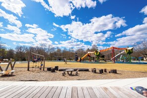Children can play on swings, slides, and climbing frames in this playground area.