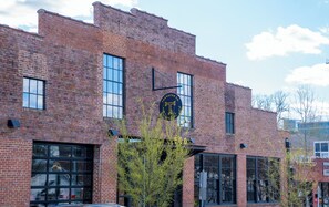 Stunning brick building with a distinctive black sign and large windows.