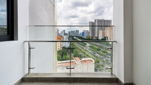A balcony with a metal railing overlooking a cityscape with buildings and a river. -  D1 Mension @ Losso (Ho Chi Minh City)