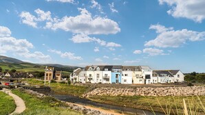 A coastal village with colorful houses, a stone wall, and a river. - 2 bedroom accommodation in Haverigg (Haverigg)