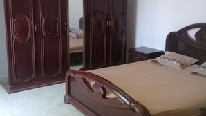 Ein Schlafzimmer mit einem Bett, einem Kleiderschrank und einem Nachttisch.
