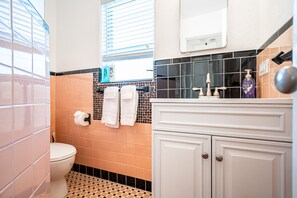 A bathroom with a toilet, sink, and towel rack. - Dan's by the Sea (Lauderdale-by-the-Sea)