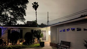 Une maison d’habitation avec un garage, une allée et un banc.