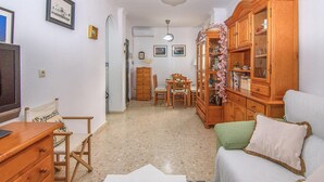 Un salon chaleureux avec un coin repas, des meubles en bois et un grand meuble de rangement.