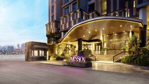 A modern hotel with a curved entrance, a visible staircase, and a cityscape view in the background. - D1 Mension Building (Ho Chi Minh City)