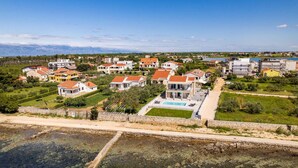 A residential area with houses, a swimming pool, and a clear view of the sea. - Cozy home in Privlaka (Privlaka)
