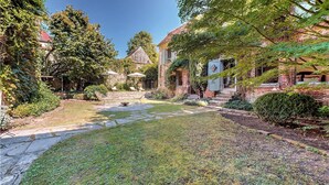 A well-maintained garden with a stone pathway leading to a seating area with chairs and umbrellas. - 5 bedroom beautiful home in Villeneuve-sur-Yonne (Villeneuve-sur-Yonne)