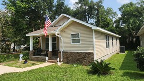 A single-story house with a front porch, a brick foundation, and a small front yard.