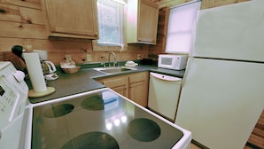 A kitchen with wooden cabinets, a stove, a sink, and a microwave. - 1 Bedroom 1 Bath Cabin with hot tub (Beaver, WV) (Beaver)