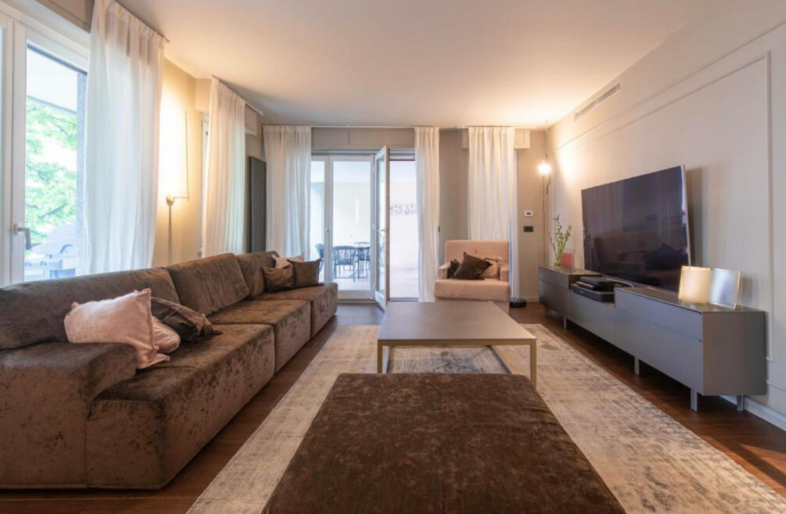 A modern living room with a sofa, a coffee table, and a TV stand.