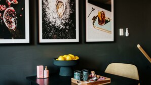 A dining table with a bowl of lemons, a bottle, and two mugs. - Midnight Moonshine Loft ITAS (LAUNCESTON)