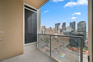 Uma varanda com vista para a cidade, uma porta e uma janela.
