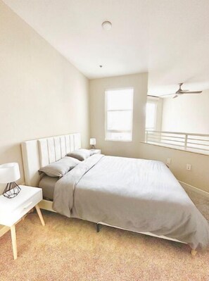 Cozy retreat with a single bed, ceiling fan, and natural light pouring in through the window.