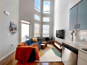 Relax in this stylish living space with a sofa, dining table, and flat-screen TV.