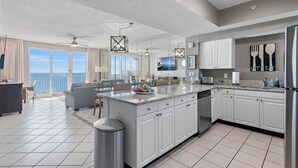 A modern kitchen with white cabinets, a large island, and a view of the ocean. - Majestic Sun A1206*12th-Top Floor*Gulf View*6 Beds*Heated Pool/Hot Tubs*Gym (Miramar Beach)