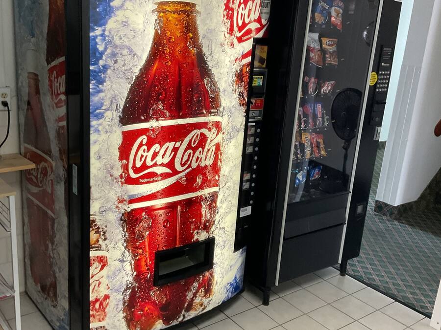 Una máquina expendedora con publicidad de Coca-Cola.