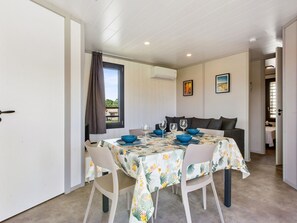 A dining area with a table set for four, featuring blue bowls and wine glasses.