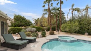A swimming pool with lounge chairs, surrounded by palm trees and landscaped garden. - Hidden Gem in Rancho Mirage (Rancho Mirage)