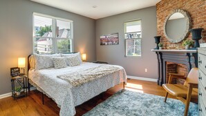 Un dormitorio con una cama grande, chimenea y vistas al exterior.