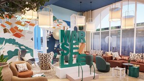 A modern living room with a large 'MARSEILLE' sign, comfortable seating, and large windows. - Près du Vieux Port | La Joliette | T2 moderne 4p (Marseille)