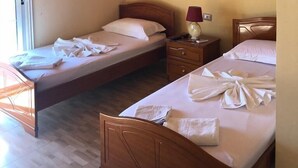 Une pièce avec deux lits en bois, une table de chevet avec une lampe et un plafond en bois.