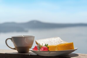 A cup of coffee, a slice of cheese, and strawberries on a plate. - Private Hot Tub, Stunning Decor & Panoramic Lake Views with Free SDC Tickets (Kimberling City)