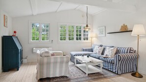 A cozy living room with a striped sofa, a small table, and a blue cabinet. - 3 bedroom stunning home in Græsted (Græsted)