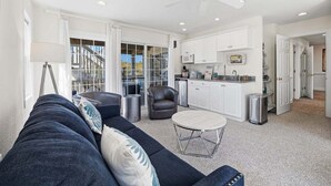Un salon moderne avec un canapé, une table basse et un ventilateur de plafond.