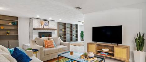 Smart TV, fireplace, books, computer monitors