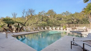 A swimming pool with lounge chairs and palm trees. - Mountain View, Resort Style Condo (Tucson)
