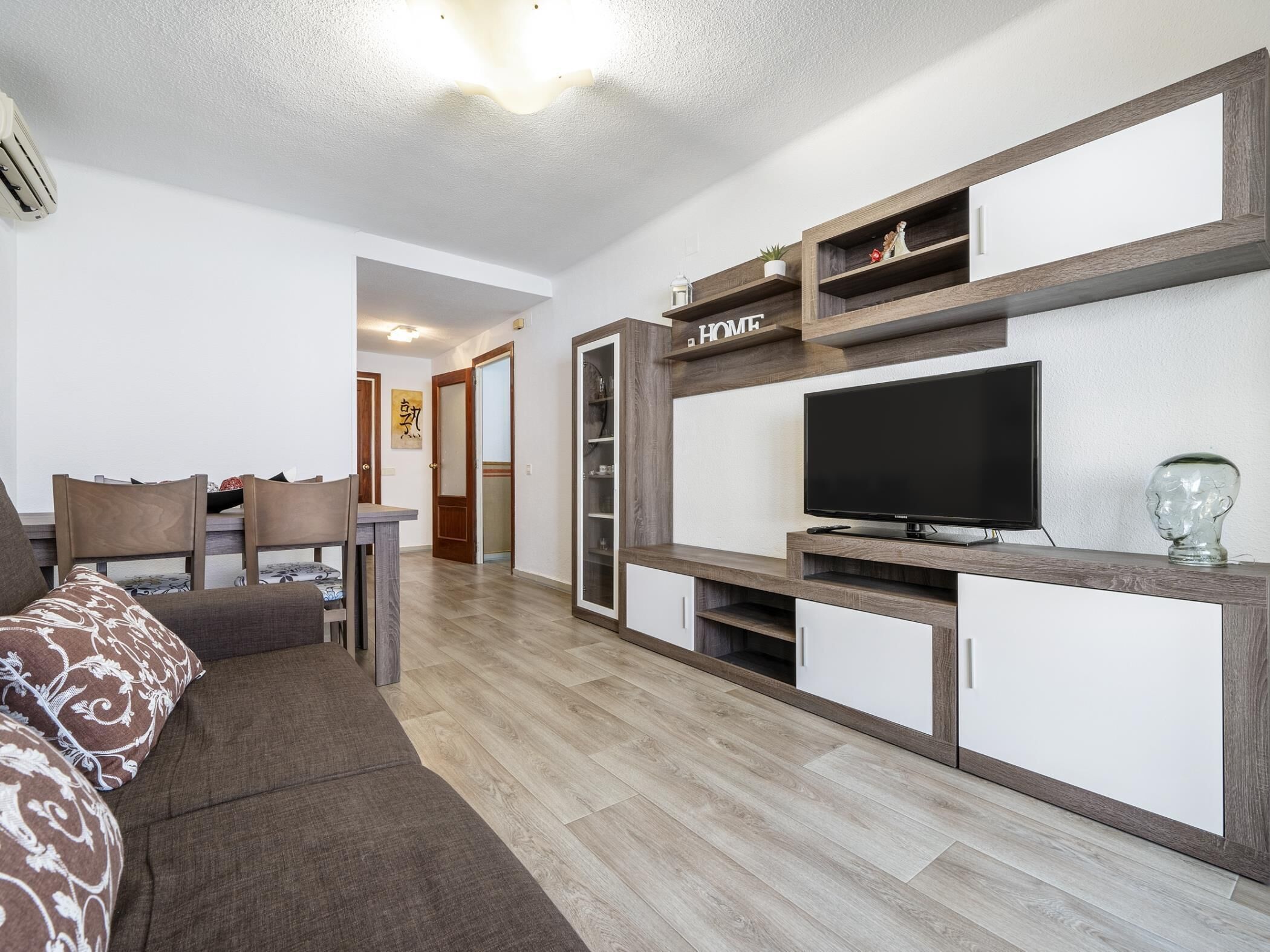 A modern living room with a sofa, TV, and built-in shelving.