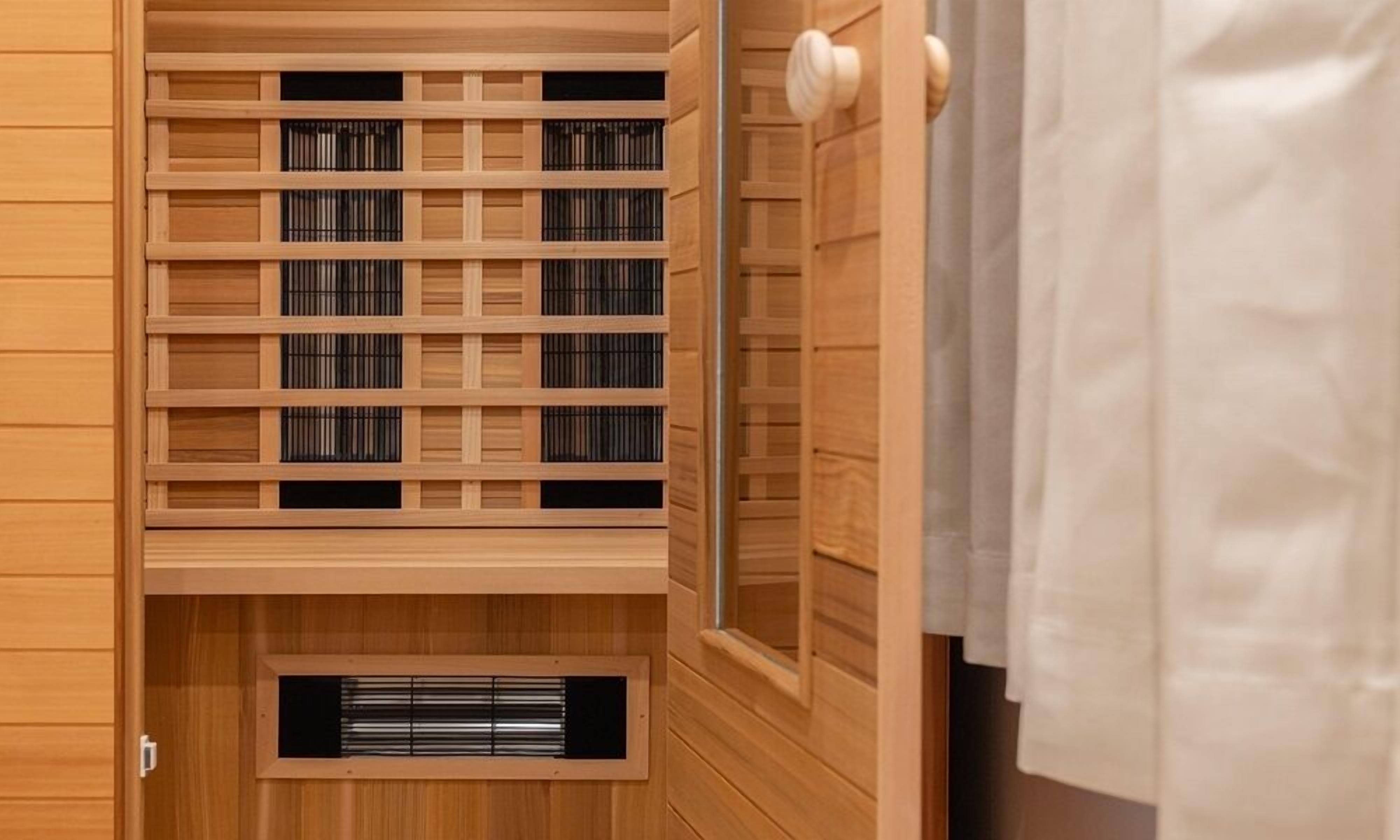Una sauna de madera con estructura de techo tipo celosía y un sistema de ventilación visible.
