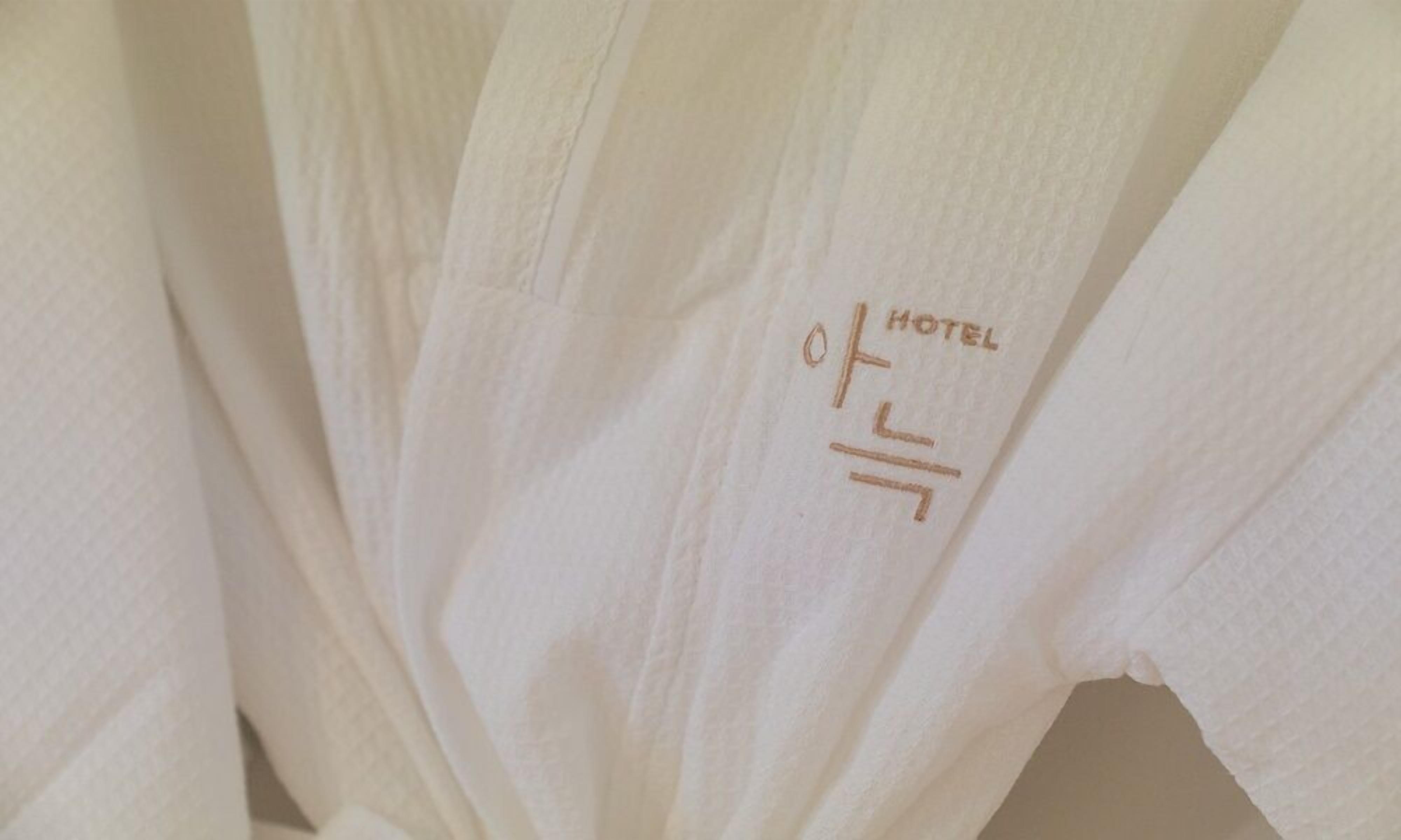 Toalla blanca de hotel con un logotipo y texto que indica el nombre del hotel.