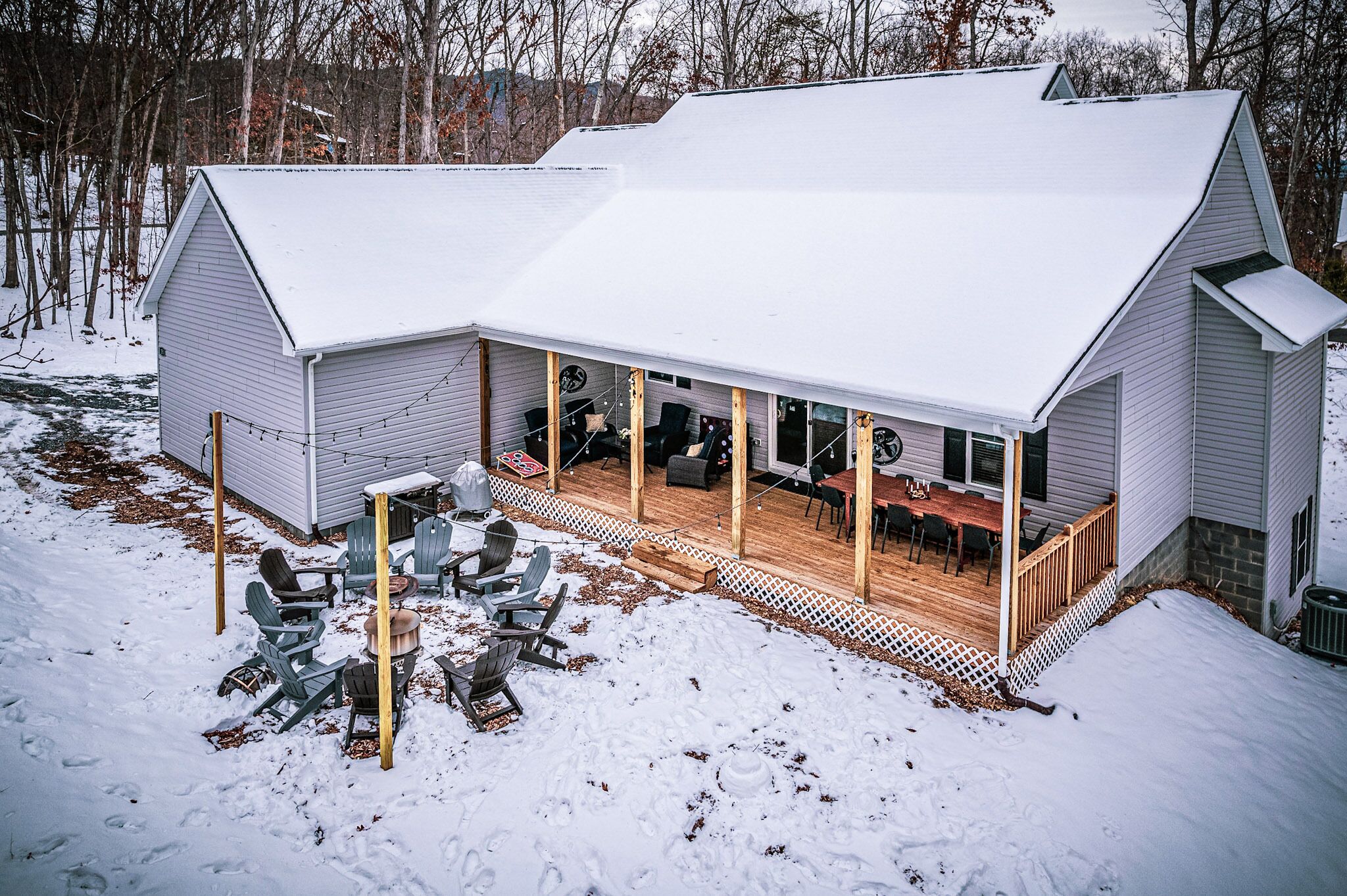 A house with a covered patio area featuring outdoor seating and a wooden deck.