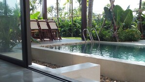 A pool area with steps leading into the water, surrounded by lush greenery and a seating area with chairs. - Apartment for 2 people on 1st floor with 1 room and 1 bathroom -Hoi An Lifestyle (Hội An)