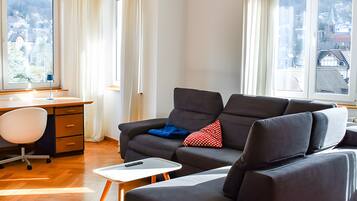 Ett modernt vardagsrum med en soffa, ett skrivbord och en stol.